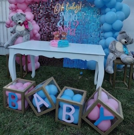 Decoración de gender reveal con globos rosas y azules, cajas “BABY” y peluches