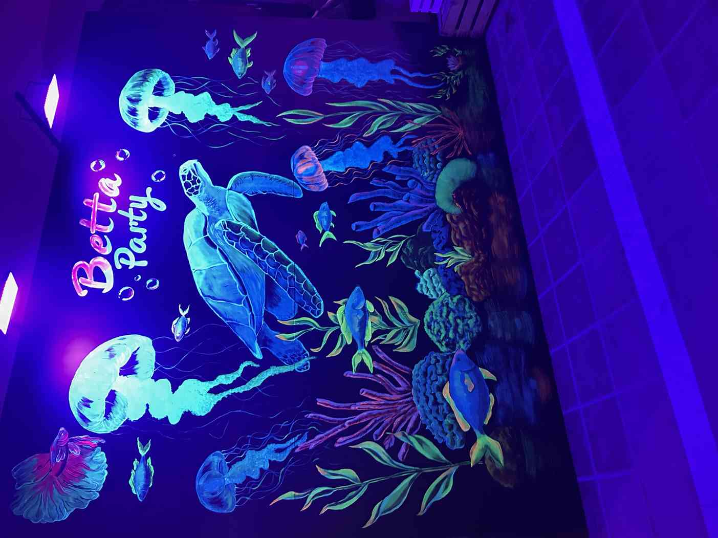 Mural neón con la marca Betta Party — decoración de fondo con criaturas marinas fluorescentes