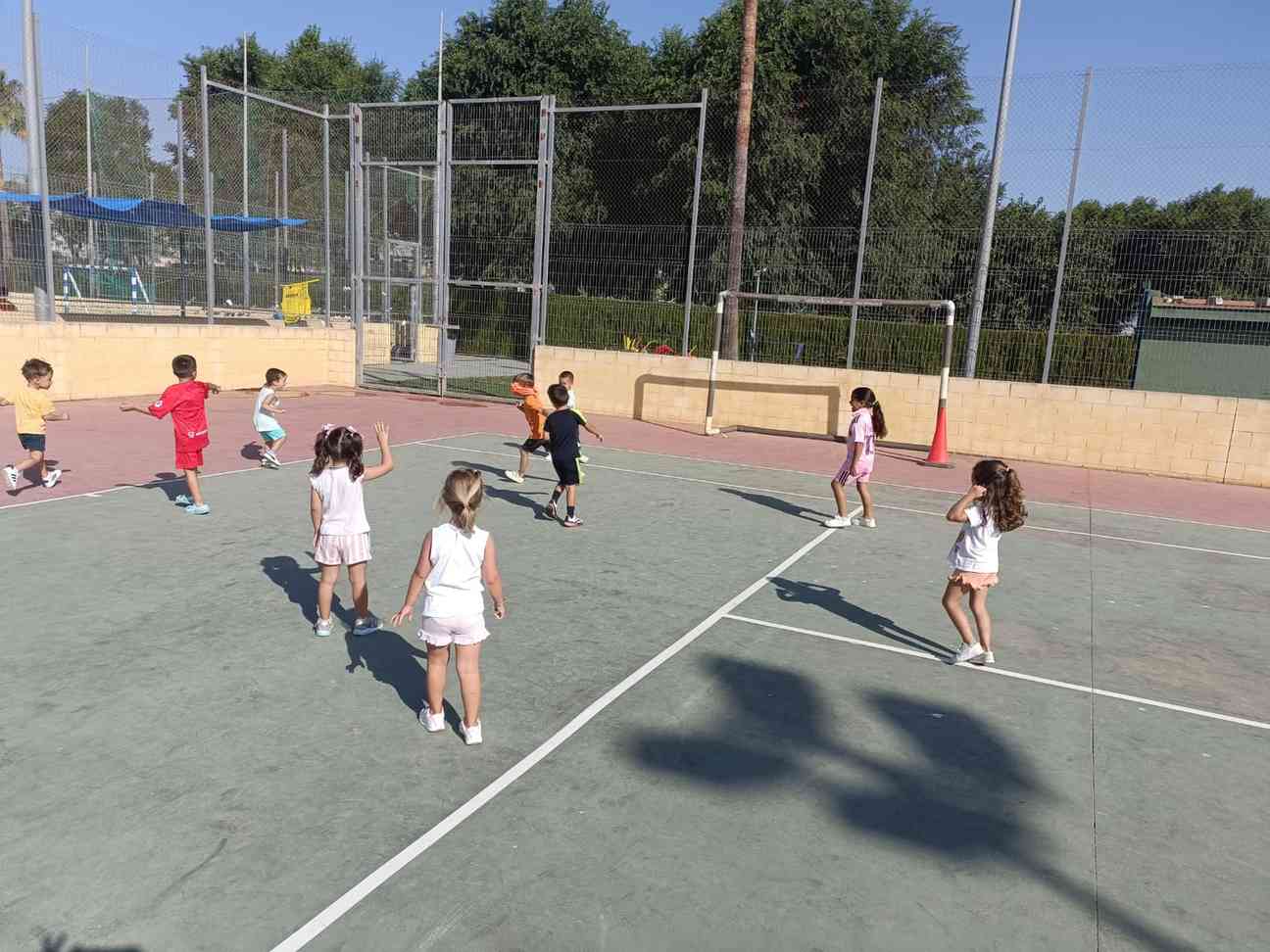 Niños jugando al fútbol en una pista polideportiva durante una actividad de Betta Eventos