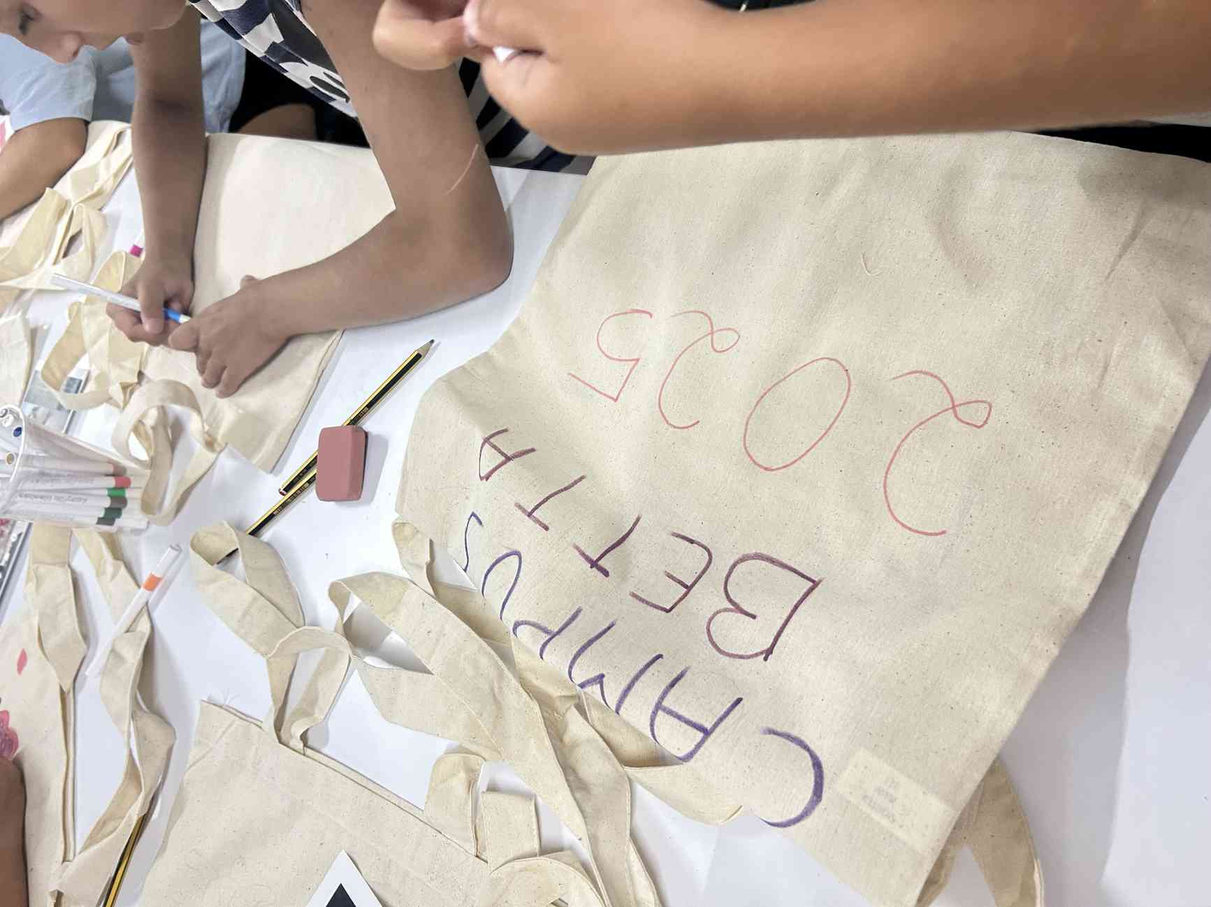 Niños personalizando bolsas de tela durante el Campus de verano de Betta Eventos